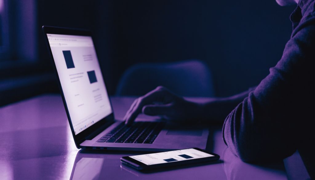 Business owner reviewing a modern company website on a laptop in a dark office a